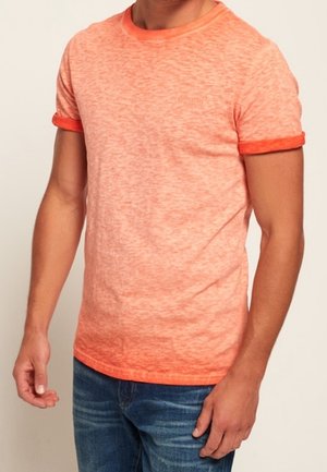 Camiseta de manga corta y cuello redondo en un tejido texturizado de color naranja claro, con un ribete de naranja ligeramente más oscuro en las mangas y el cuello.