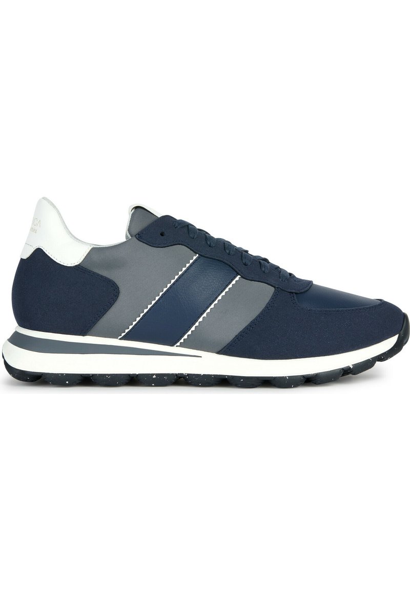 Sneaker sportive blu navy con accenti grigi, materiali lisci e testurizzati, suola bianca piatta e due dettagli a strisce diagonali.
