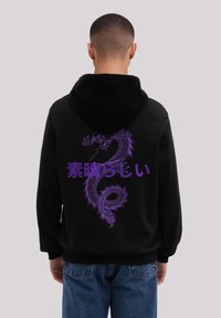 Sudadera negra con un gran gráfico de dragón púrpura y texto japonés. El material parece suave, con un ajuste clásico y bolsillo tipo canguro.