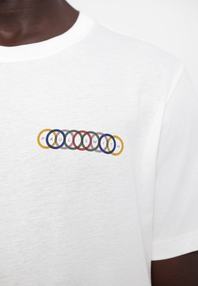 Valge T-särk, millel on multivärviline ringikujuline graafika ja peal kirjaga "PAUL SMITH" suurtes tähtedes, valmistatud pehmest puuvillast materjalist.