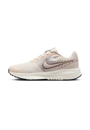 Jasnobeżowy but biegowy Nike z oddychającą siateczkową cholewką, białą amortyzowaną podeszwą oraz szarym logo Swoosh po boku.