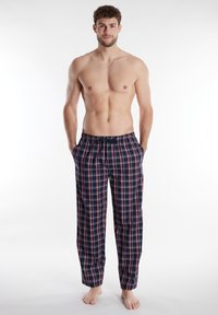 Pantalones de pijama de cuadros para hombre en azul marino y rojo, con una cinturilla elástica, dos bolsillos laterales y un corte holgado. Fabricación en suave algodón.