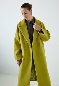 Cab coat croisé en mélange de laine vert citron vif. Présente un revers à col cranté, une coupe décontractée et de grands boutons. Doublure intérieure lisse.