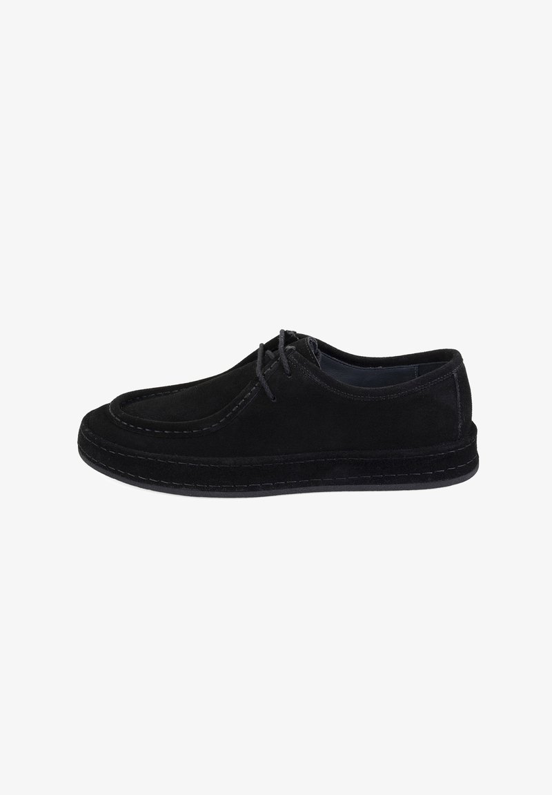 Chaussure en suède noir avec un bout arrondi, un design à lacets, des coutures contrastantes et une semelle plate. Design simple et épuré sans accents supplémentaires.