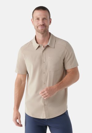 Short-sleeve button-up shirt in light beige, made of smooth fabric. Features a collar and a chest pocket. Straight hem design.