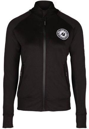 Zwarte zip-up jack met een hoge kraag, voorzien van twee zijzakken met rits en een rond logo op de linkerborst. Gladde stofstructuur.