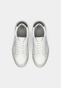 Pair of white and gray BOSS sneakers with laces, ortholite insoles, and suede toe caps, shown from above on a white background.
