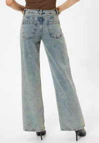 Ljusblå vida jeans med hög midja, fem fickor och sömnadsdetaljer, tillverkade av denim med en lätt urtvättad textur.