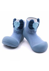 Calcetines infantiles azul con suela de goma texturizada, que presentan un diseño de elefante tejido en el tobillo y suaves acentos de toalla en las orejas.