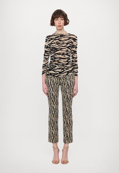 Long-sleeve top and pants set, featuring a beige and black abstract pattern, soft fabric, fitted silhouette, and ankle-length cut.