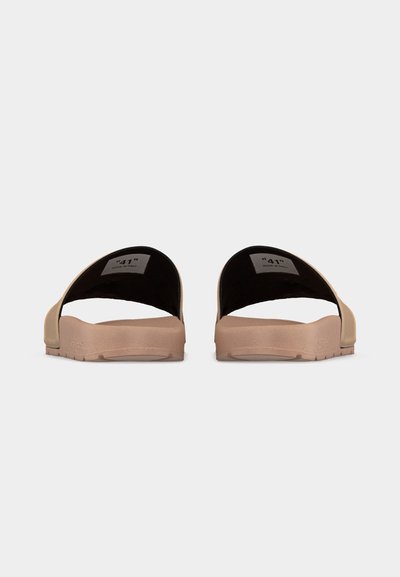 Μπεζ σανδάλια με λωρίδες εσωτερικά σε μαύρο χρώμα, ετικέτα μεγέθους "41" ορατή στο εσωτερικό, εμφανιζόμενα από πίσω σε λευκό φόντο.
