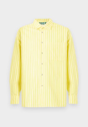 Camisa amarilla de manga larga con botones, rayas verticales blancas, cuello, bolsillo frontal y puños, mostrada sobre un fondo neutral.