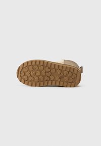 Sola de bota castanha com aderência texturizada, apresentando padrões em forma de coração. Feita de borracha com um design estruturado, evidenciando uma construção robusta e durável.
