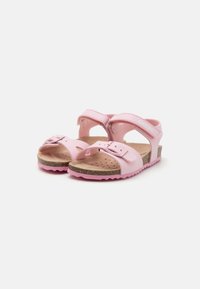 Rosa sandaler med gummisåle, korkfotbed og to justerbare borrelåsremmer. Har et utskåret design og teksturert detaljer.