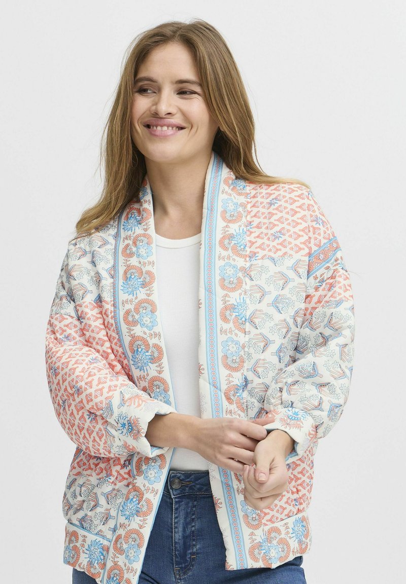 Giacca trapuntata con motivi floreali e geometrici in corallo, azzurro chiaro e bianco, dotata di un ampio colletto e vestibilità comoda.