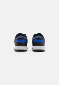 Sorte og blå Nike sneakers med en tekstureret overflade, polstret krave, hvid mellemsål og sort gummisål, der viser brandets logo på hælen.