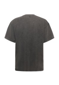 Camiseta de algodón de color gris oscuro con un corte holgado, mangas cortas y cuello redondo. Textura suave con un acabado lavado desteñido.