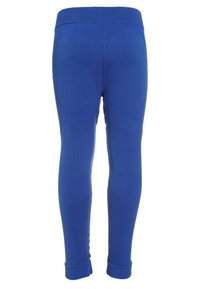 Blaue Leggings mit einem gerippten Bund, glatter Textur und tailliertem Design. Verfügt über subtile Muster entlang der Seiten und an den Knöcheln.