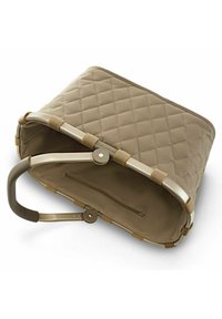 Borsa in tessuto trapuntato beige con una struttura rigida, dotata di manico in metallo e tasca interna con zip. Texture liscia con una forma strutturata.