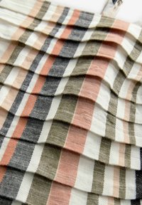 Textiel met geplooide lagen in afwisselende strepen van beige, lichtroze, donkergroen en marineblauw. Zachte, getextureerde afwerking overal.