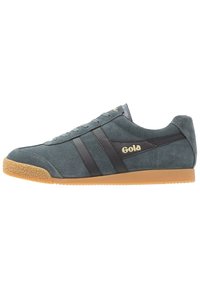 Sneakers Gola in suede grigio con strisce in pelle nera e logo dorato. Punta arrotondata e suola in gomma testurizzata. Stile atletico classico.