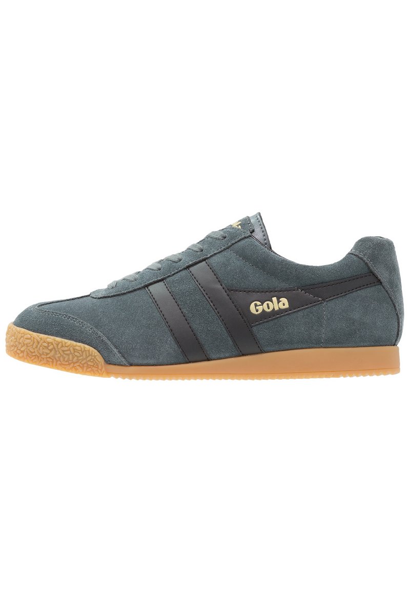 Sneakers Gola in suede grigio con strisce in pelle nera e logo dorato. Punta arrotondata e suola in gomma testurizzata. Stile atletico classico.