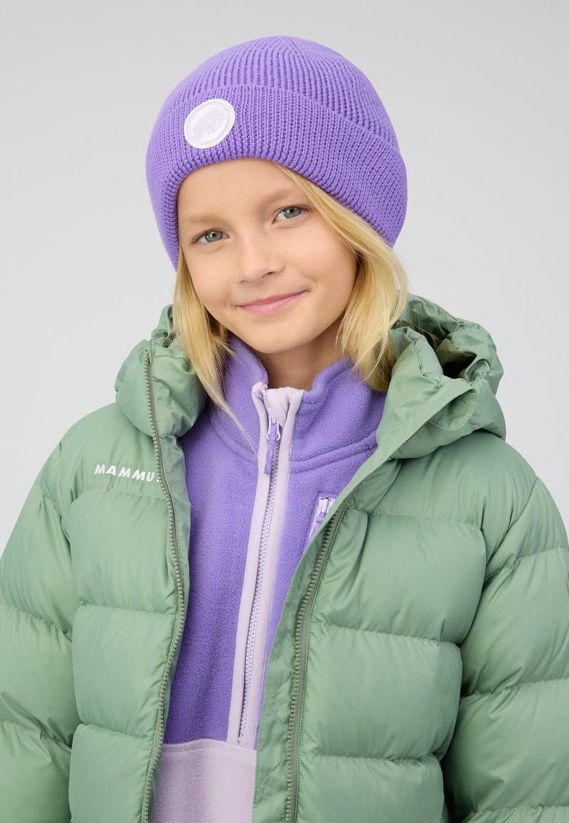 Lichtgroene pufferjack en paarse gebreide beanie. De jas heeft een ritssluiting en capuchon; de beanie heeft een geribbelde textuur en een logo patch.