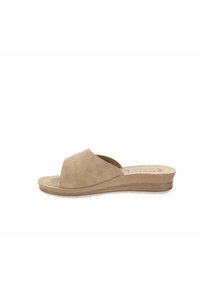 Sandal in suede beige con design open toe, tacco basso a zeppa, dettagli intagliati sulla suola e cuciture minime sulla parte superiore per un tocco in più.