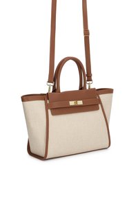 Beżowa torba na ramię z płótna z brązowymi skórzanymi akcentami i uchwytami, wyposażona w odpinany pasek na ramię oraz złote zapięcie na klapie.