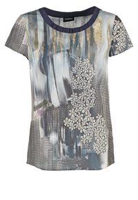 Haut féminin à manches courtes avec des coups de pinceau abstraits bleu-gris et or, une application en dentelle florale blanche et des motifs noirs à pois.