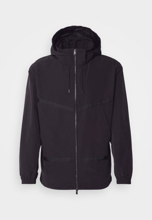Black hooded jacket made of lightweight material, featuring a front zip, elastic cuffs, and horizontal stripe accents.