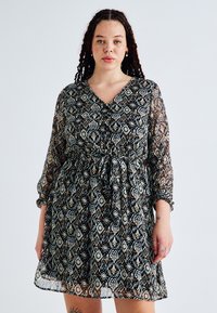 Μαύρο φόρεμα με μοτίβο, διαφανείς μακριές μανίκια, v-λαιμόκοψη, ελαστική μέση και φαρδιά φούστα που διαθέτει λουλουδάτα και γεωμετρικά σχέδια.