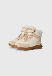 Beige mellomhøye støvler med faux fur-krage, som har gull øyealter, rosa og hvite snorer, og en teksturert gummisåle for grep.