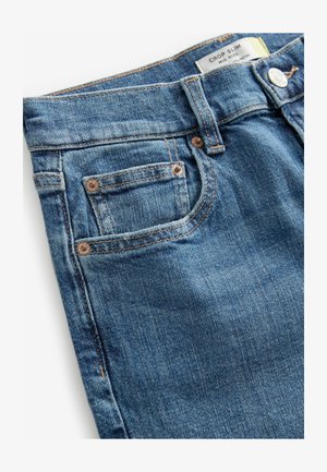 Heledad teksased helesinis, kitsas ja lühendatud disainiga. Omab viit taskut, vasktooteid ja kontrastset õmblust. Pehme tekstuur.