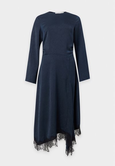 Robe bleu marine à manches longues avec un col rond, un ourlet asymétrique et une bordure en dentelle noire le long des bords inférieurs.