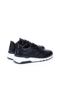Black leather sneakers with a textured finish, featuring a white midsole and black outsole, lacing system, and accent details near the tongue.