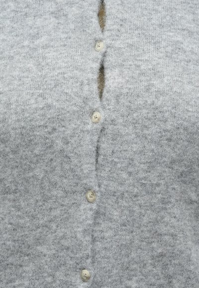 Γκρι πλεκτή ζακέτα με απαλό υφή, που διαθέτει μια σειρά από πέντε ανοιχτόχρωμα κουμπιά και μερική πατιλέτα κουμπιών στο κέντρο.