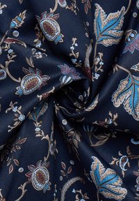 Tessuto navy con intricati motivi floreali e paisley nei toni del blu, bordeaux e oro, caratterizzato da una superficie liscia e testurizzata.
