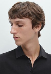 Schwarzes Polohemd mit Kragen und Knopfverschluss. Glattes Material und klassisches Design, mit kurzen Ärmeln und taillierter Passform.