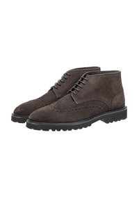 Brown suede chukka boots featuring perforated detailing, round toe, and contrasting black rubber sole; six lace-up eyelets.