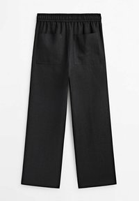 Pantalon noir à jambes larges avec taille élastique et deux poches arrière carrées, présenté à plat sur un fond blanc.