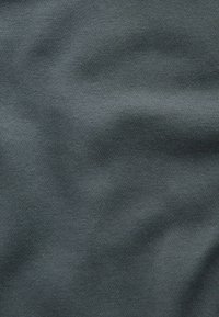 Tissu gris foncé à texture lisse, présentant un motif côtelé. La surface affiche des ondes subtiles et de légères variations de brillance.