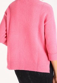 Maglione in misto lana di un vivace rosa, con una vestibilità relaxed, maniche a tre quarti, orlo a coste e una texture morbida.