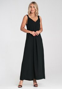 Schwarzes Maxikleid mit V-Ausschnitt und breiten Trägern, aus leichtem Stoff. Hat eine entspannte Passform und fließendes Design, das bis zu den Knöcheln reicht.