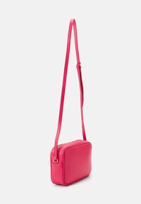Borsa a tracolla rettangolare rosa con una texture in pelle liscia, cinturino sottile e regolabile, e chiusura con zip nella parte superiore, caratterizzata da bordi arrotondati.