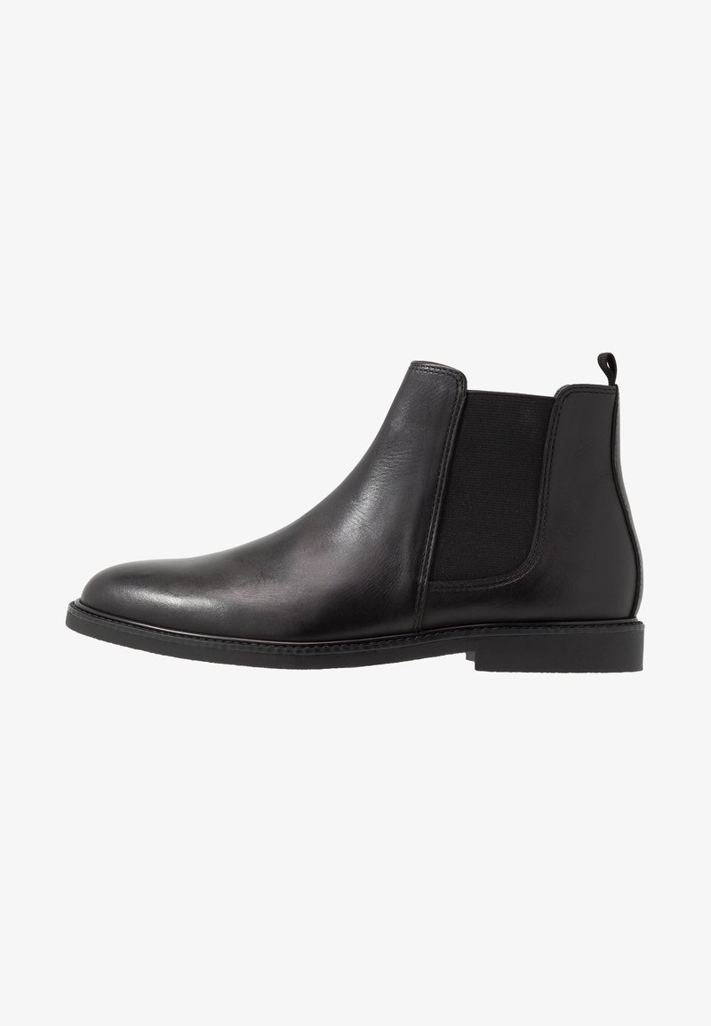Botte Chelsea en cuir noir avec panneau latéral élastique et petit talon, vue de profil sur fond blanc.