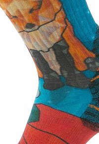 Calzini colorati con un design geometrico di una volpe in arancione, marrone e nero su uno sfondo turchese, con costine texturizzate al polsino.