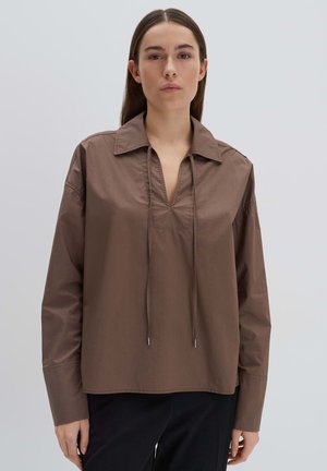 Camicia marrone a maniche lunghe con colletto, mezza patta e dettagli con cordoncino. Texture liscia, vestibilità morbida e design minimalista.