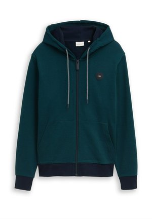 Dunkelgrüner Kapuzenpullover mit Reißverschluss, Kapuze, weißen und schwarzen Kordeln, Taschen vorne, gerippten Bündchen und Saum sowie kleinem rundem Logo auf der Brust.