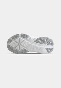 Semelle de chaussure en blanc et gris clair avec des motifs en caoutchouc texturé, présentant des formes triangulaires et géométriques pour l'adhérence et la traction.